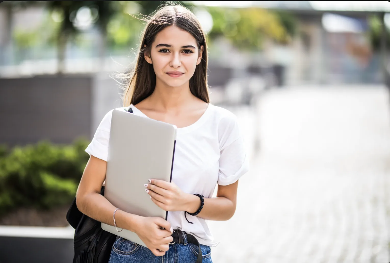 Étudiante en alternance, ordinateur portable sous le bras