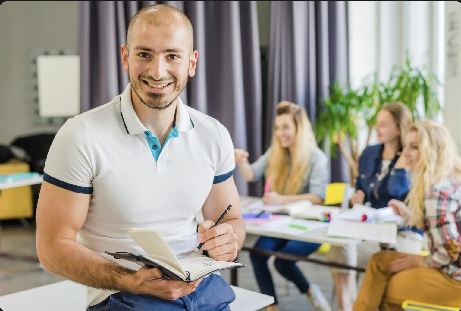 Coordinateur souriant en salle de classe, étudiants en fond